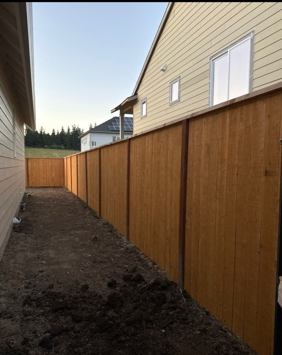 Long cedar privacy fence run down the side of a house